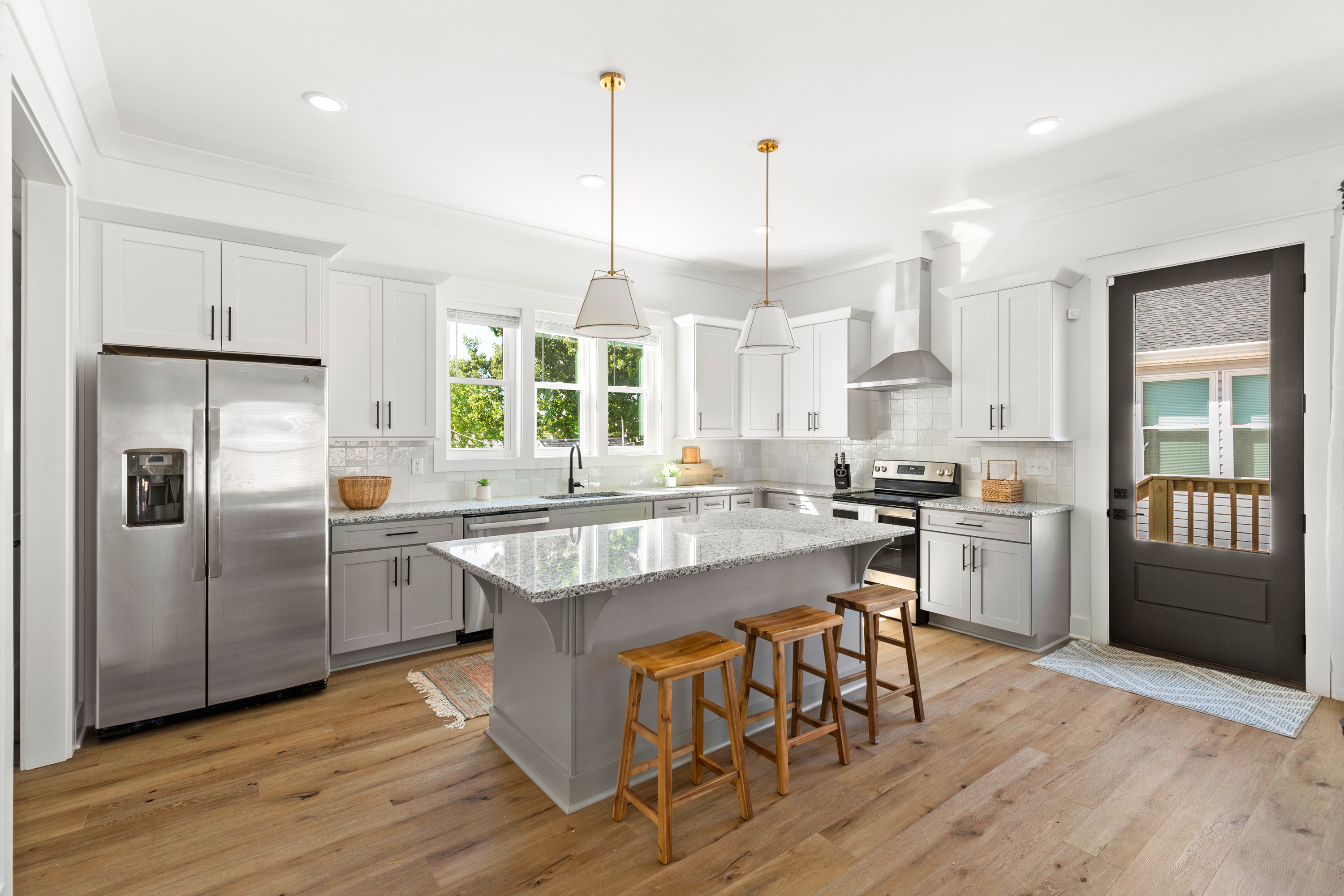 Modern kitchen with white cabinets, granite countertops, and pendant lighting